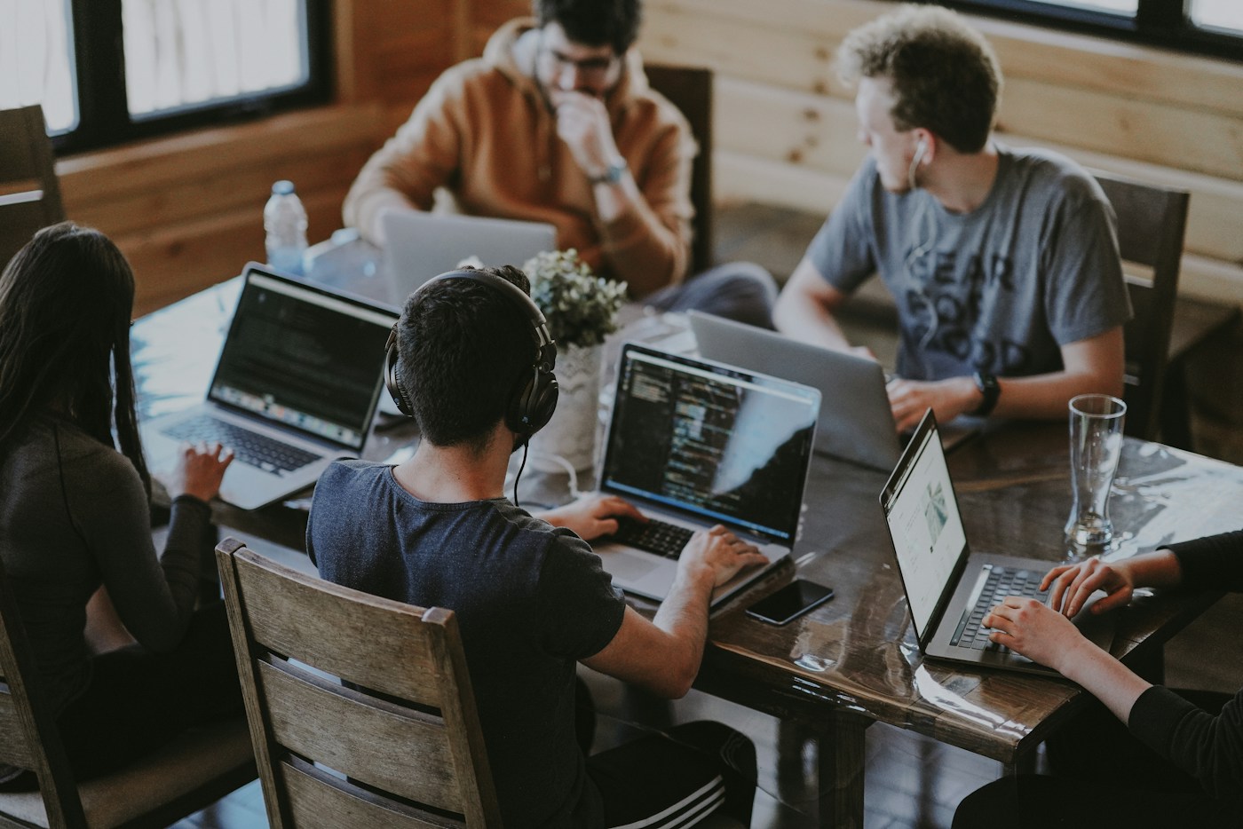 Professionals collaborating around a table with laptops